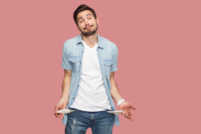 Hombre mostrando bolsillos vacíos, imagen que ilustra la sensación de escasez económica y falta de dinero.