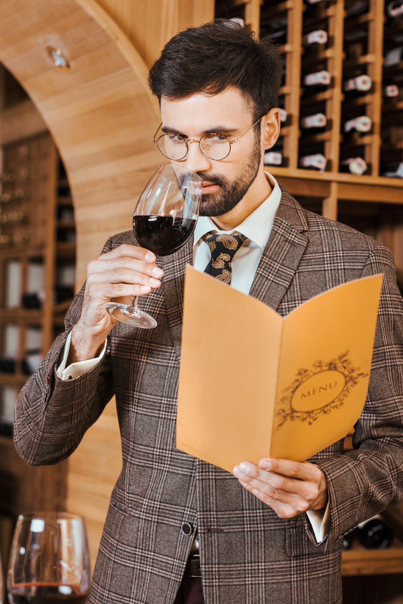 Professional wine taster swirling a glass of red wine